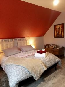 a bedroom with a large bed with a red wall at Bien être et détente chez côté campagne et jardin in Ohnenheim