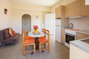 a kitchen with a table and chairs in a kitchen at Nea Kydonia suites and studios in Daratso