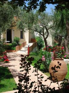 a garden with a large vase in a yard at Nea Kydonia suites and studios in Daratso