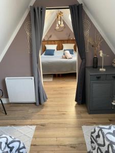 a bedroom with a canopy bed in a attic at Appartement au gré des bulles in Cucq