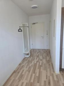 an empty room with white walls and a wooden floor at Ganz Apartments in Fürth +3 photos