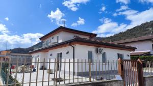 a white house with a fence in front of it at Pozzilli Affitacamere Appartamenti in Pozzilli