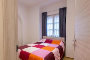 a bedroom with a colorful bed in front of a window at Apartments and holidays Cav Chiara Tione di Trento in Tione di Trento