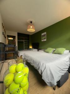 a bedroom with two beds and a bowl of tennis balls at Le Wimbledon in Chalon-sur-Saône +14 photos