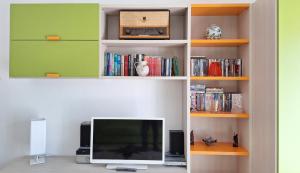 a living room with a tv and books at Casa Iolanda in Riposto