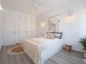 a white bedroom with a large bed and white cabinets at Boho house, Albufeira in Albufeira
