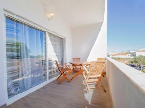 a balcony with a table and chairs and a large window at Boho house, Albufeira in Albufeira