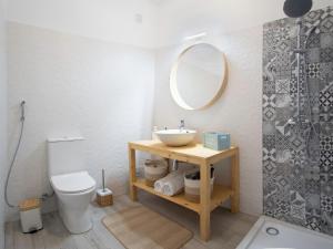a bathroom with a sink and a toilet and a mirror at Boho house, Albufeira in Albufeira +12 photos