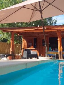 an umbrella and chairs next to a swimming pool at Espacio Reservado in Valle Hermoso +21 photos