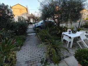 a patio with a white table and chairs in a yard at B&b GIOIA in Massa Lombarda