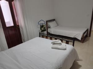 a room with two beds with towels on them at Dar Mifa in Martil