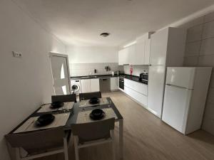 a kitchen with a table and a white refrigerator at Casa da vinha in Anreade