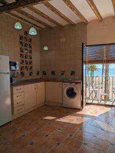 a kitchen with a washing machine in a room at Kiboko Beach in Villajoyosa