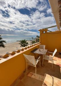 a patio with a table and chairs and the beach at Kiboko Beach in Villajoyosa