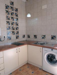 a kitchen with a sink and a washing machine at Kiboko Beach in Villajoyosa