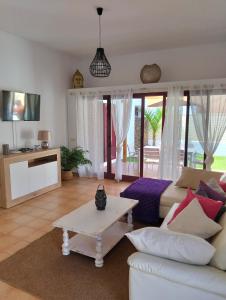 a living room with a white couch and a table at Casa Vacacional Villa Liberty in Corralejo