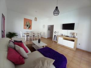 a living room with a couch and a tv at Casa Vacacional Villa Liberty in Corralejo