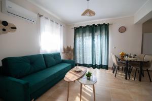 凯法洛斯Anthos Residence 2的客厅里有一张绿色的沙发和一张桌子
