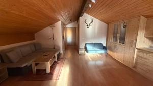 a living room with a couch and a blue chair at Ferienwohnung Alpenblick in Anger
