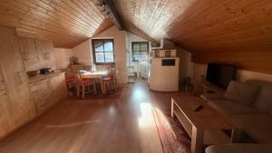 a kitchen and a living room with a table and a refrigerator at Ferienwohnung Alpenblick in Anger