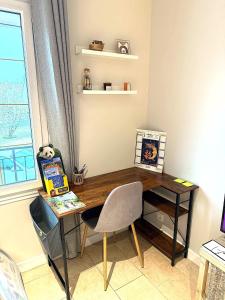 a desk in a room with a chair and a window at Les mésanges, 10m Zoo de Beauval, climatisation in Noyers-sur-Cher