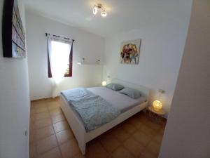 a white bedroom with a bed and a window at Casa Vacacional Villa Liberty in Corralejo +32 photos