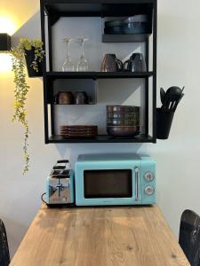 a blue microwave sitting on top of a wooden table at Appartement standing 500m de la plage ! in Dunkerque