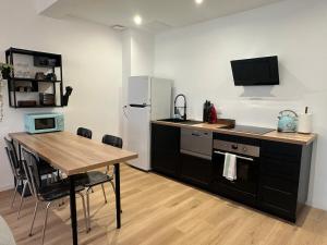 a kitchen with a table and a refrigerator at Appartement standing 500m de la plage ! in Dunkerque