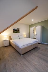 a bedroom with a large white bed in a room at Frisch renovierte Zimmer in Sehnde +6 photos