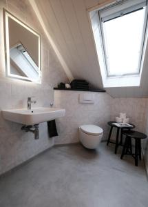 a bathroom with a sink and a toilet and a skylight at Frisch renovierte Zimmer in Sehnde
