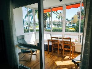 a dining room with a table and chairs and windows at Cayo Beach in Torrox Costa