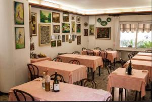 a restaurant with tables and chairs and pictures on the wall at Incantevole appartamento sul mare - Borgo Marina in Imperia