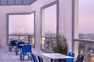 a balcony with tables and chairs and windows at The Originals Résidence Paris Sud Villejuif in Villejuif