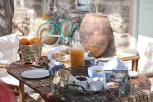 a table with breakfast foods and a bottle of juice at Stone houses Areti 2 in Manganítis