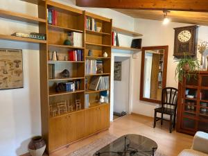 a living room with a large wooden book shelf at Casa Añeja in Collbató