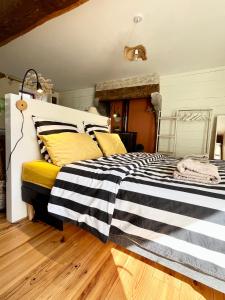 a bedroom with a bed with black and white stripes at Maison à la campagne Les Oliviers in La Bruffière