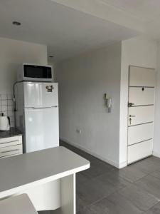 a white kitchen with a white refrigerator and a counter at Departamento por día céntrico "Uxue" - capacidad hasta 3 personas in Tandil
