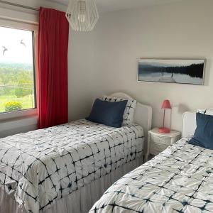 a bedroom with two beds and a window at Blue House On The Hill - Year Round Cottage in Turriff