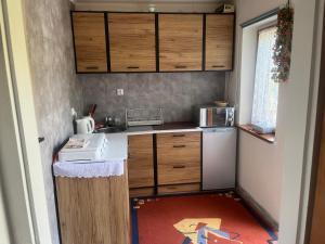 a small kitchen with a sink and a refrigerator at Wiejska Sielanka w Garbatce-Letnisku in Garbatka-Letnisko