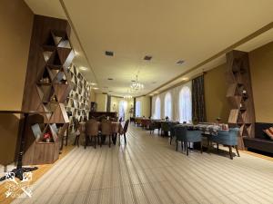 a dining room with tables and chairs in a room at Chateau Qusar Hotel & Restaurant in Qusar
