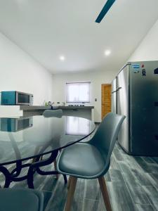 a kitchen with a glass table and a refrigerator at Departamento Arrecife in La Paz