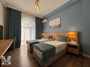 a hotel room with two beds and a window at Chateau Qusar Hotel & Restaurant in Qusar