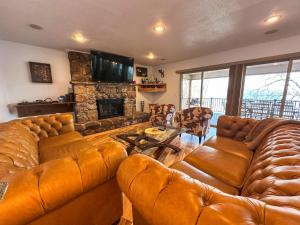 een woonkamer met een leren bank en een open haard bij Lakehouse Wpools, Hottub, Dock, Sauna,playground in Sunrise Beach