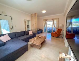 a living room with a blue couch and a coffee table at Sea Lullaby in Drymonas