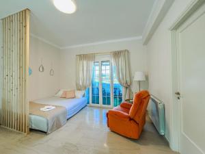a bedroom with a bed and a chair and a window at Sea Lullaby in Drymonas