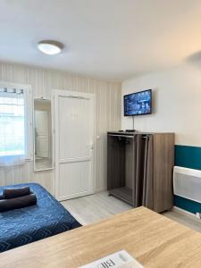 Habitación con cama y TV en la pared. en Studio confort - Portet-sur-Garonne, en Portet-sur-Garonne