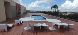 a patio with two tables and chairs and a pool at Delta Prime HOTEL in Parnaíba