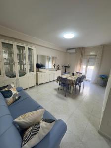 a living room with a blue couch and a table at Casa Vacanze Miramare in Porto Empedocle
