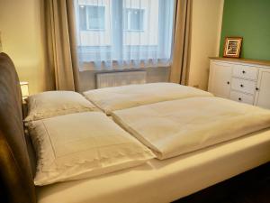a bed with two pillows on it with a window at Apartment Astrid in Zell am See