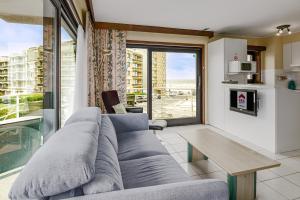 un soggiorno con un divano e una grande finestra di Roya G7 a Koksijde